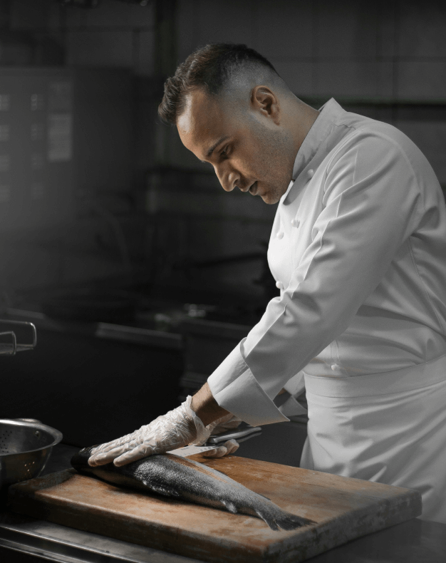 A chef cutting fish on a board