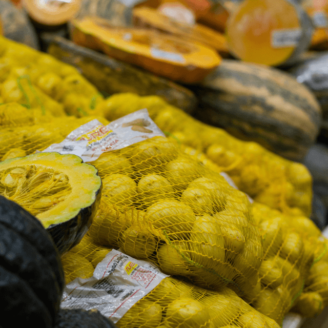 A shelf in a store with potato in nets